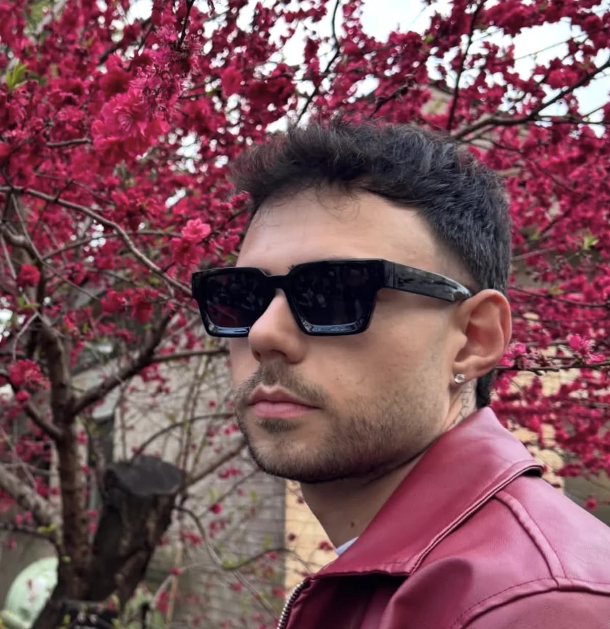 Alex, Italian barber at Barberhood Toronto, in sunglasses under cherry blossoms