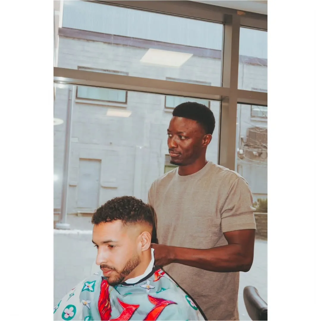 Barber performing a fade haircut at Barberhood Liberty Village